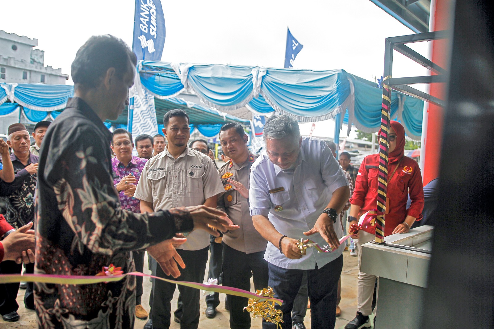 Caption: Bupati Bangka Barat Sukirman potong pita tanda peresmian pasar Parittiga, Kamis (1/2/2024). (Diskominfo Babar)