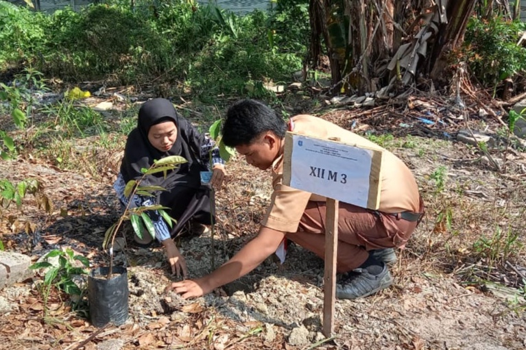 Foto : Siswa SMA Negeri 1 Parittiga bersama guru menanam pohon Durian di Halaman Belakang Sekolah, pada Kamis (25/9/2024). Saat penanaman pohon serentak Babel.(Babelhits.com).