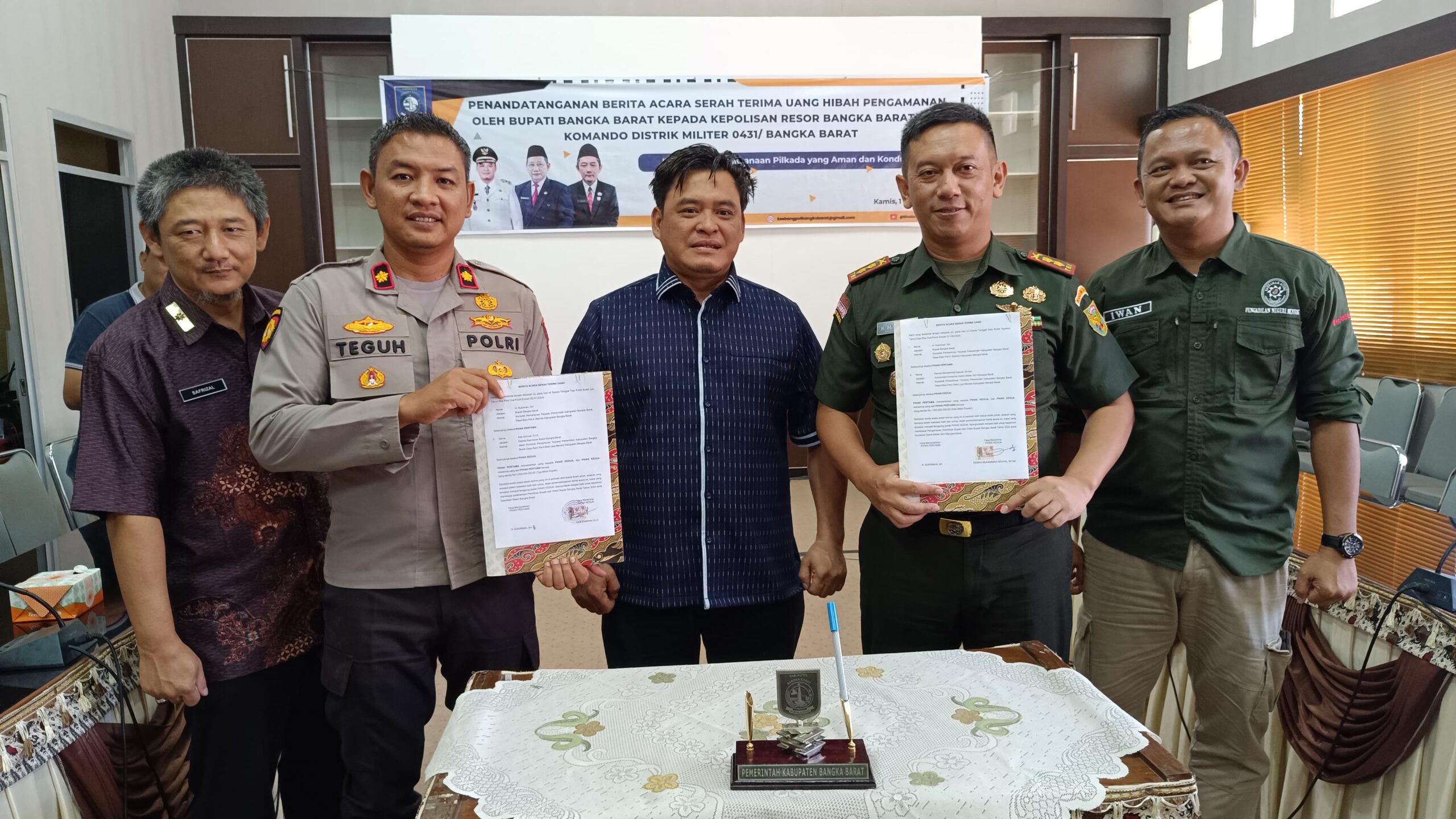 Caption: Wakil Bupati Bangka Barat Bong Ming Ming serahkan dana hibah ke Polres dan Kodim 0431/ Bangka Barat di Operational Room I, Setda Pemerintah Kabupaten Bangka Barat, pada Kamis (1/8/2024).