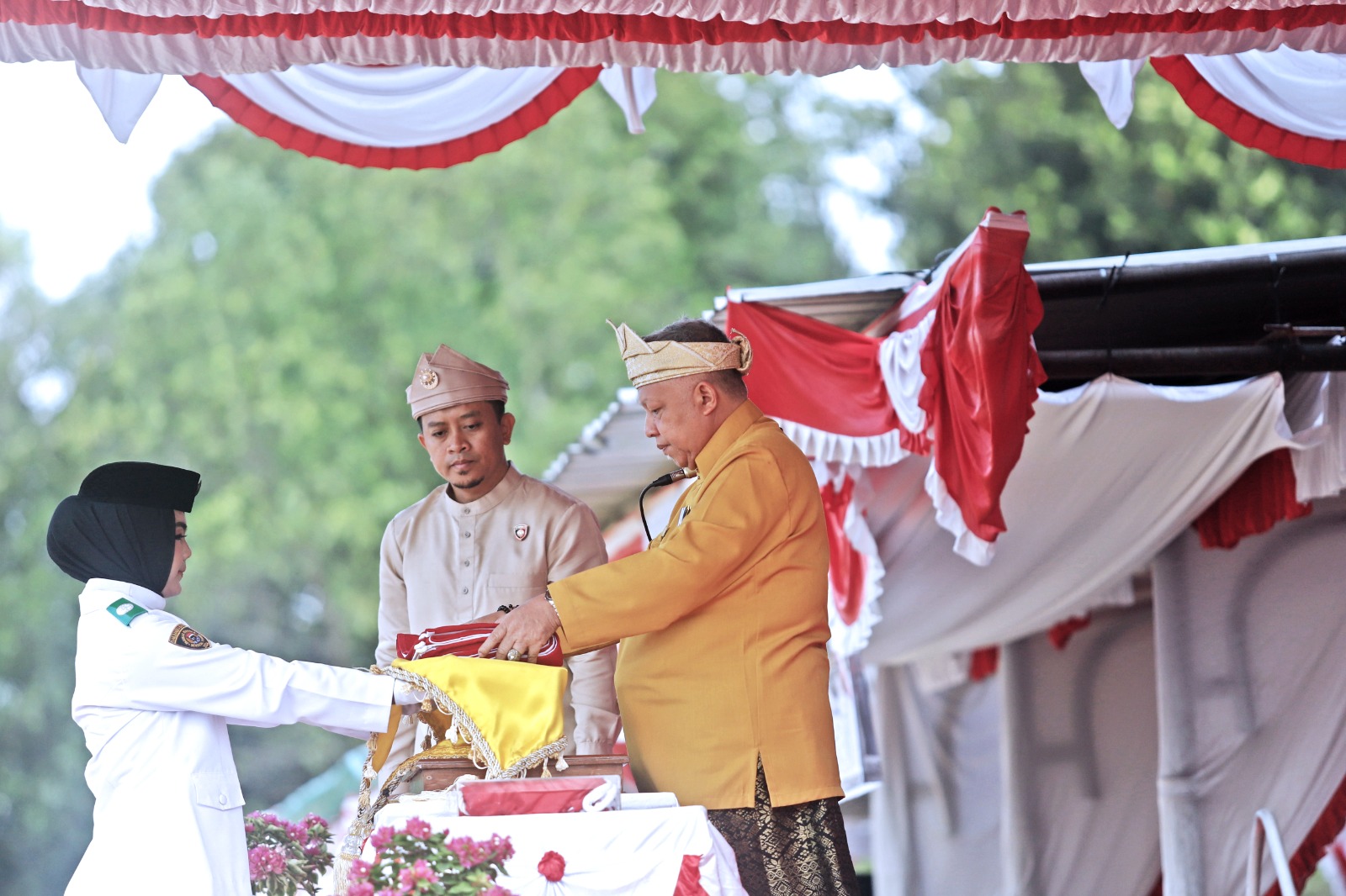 Bupati Bangka Barat Sukirman memberikan bendera merah putih ke pembawa baki untuk dikibarkan.